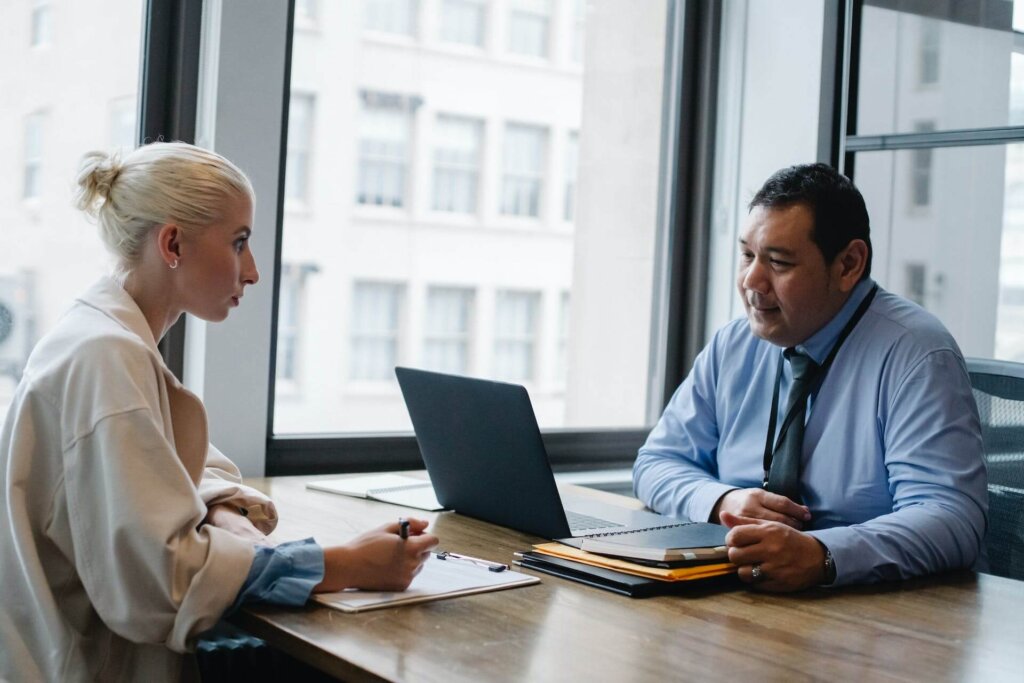 A man sitting at a table interviewing a woman